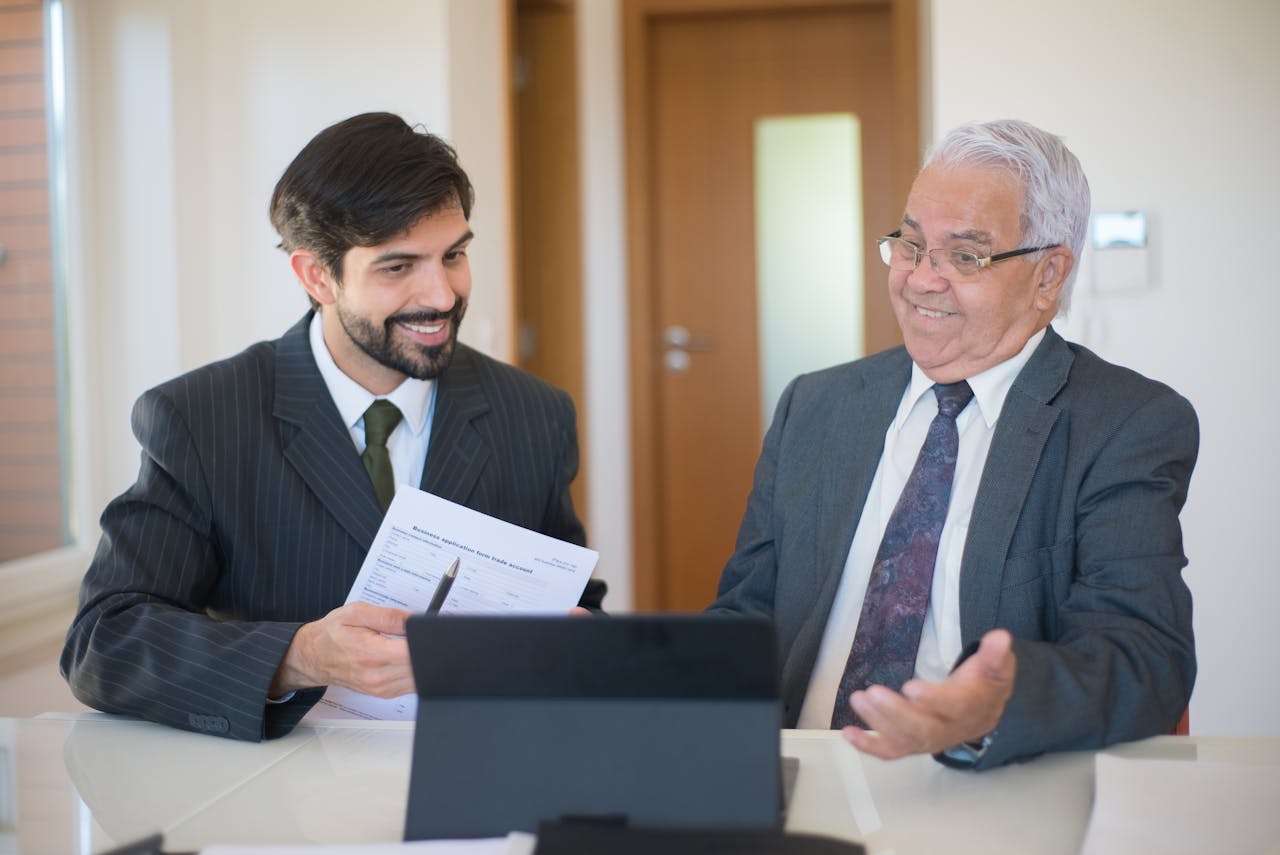Two businessmen discussing a real estate deal in a modern office setting.